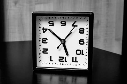 Inverted clock with arrows in black and white close up
