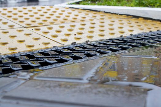 Rain grate on the sidewalk in the rain close up