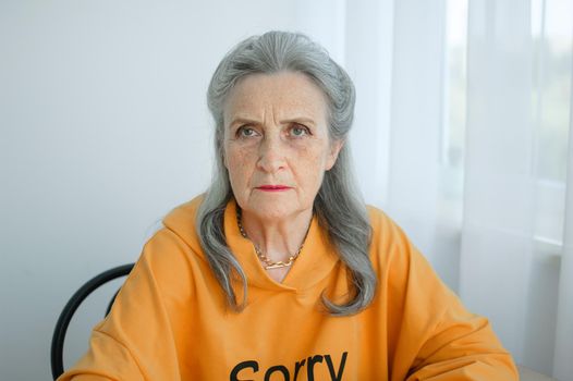 Closeup portrait of angry upset senior mature woman talking with someone and looking at the camera. Negative emotion, facial expression, scandal.