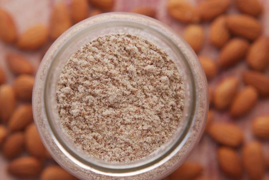 almond powder in a jar and almond on table ,