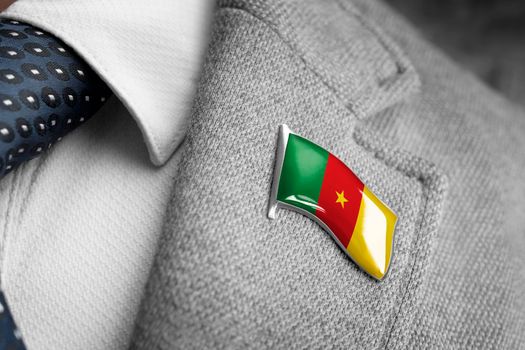Metal badge with the flag of Cameroon on a suit lapel.