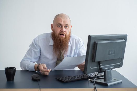 Portrait of a bald man at a desk looking at a report and cursing. The dissatisfied boss dismisses the subordinate