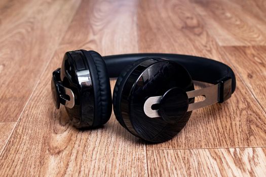 Black headphones on a wooden table close up