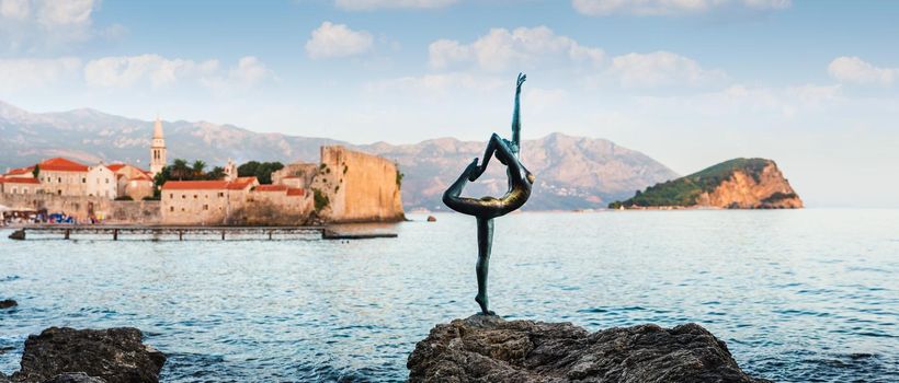 Sculpture of dancer girl in Budva, Montenegro, Balkans, Europe. Old town and mountains in backround.