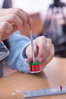 Pupil's hand put weight on the physical barbell close-up. A schoolboy performs a task at the workplace. The concept of children's education, teaching knowledge, skills and abilities.