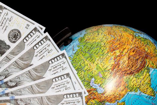 Dollar bills and globe on a black background