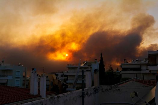 Smoke from the fire in Varibobi at Athens as seen from a house roof. Athens, Greece.