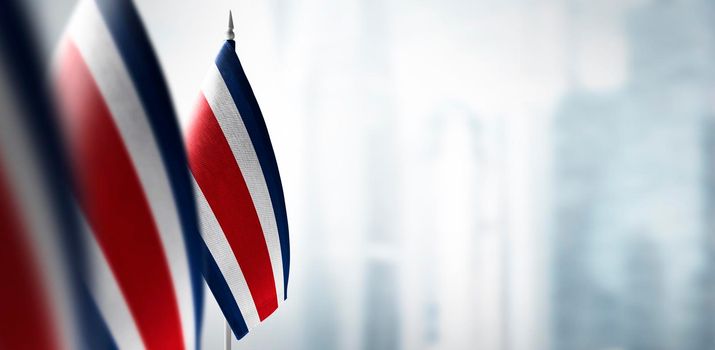 Small flags of Costa Rica on a blurry background of the city.