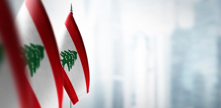 Small flags of Lebanon on a blurry background of the city.