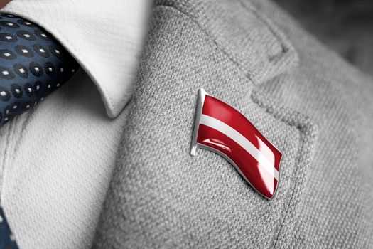Metal badge with the flag of Latvia on a suit lapel.
