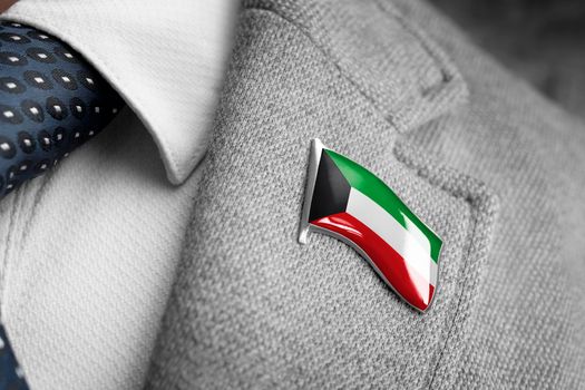 Metal badge with the flag of Kuwait on a suit lapel.