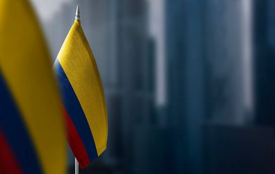 Small flags of Colombia on a blurry background of the city.