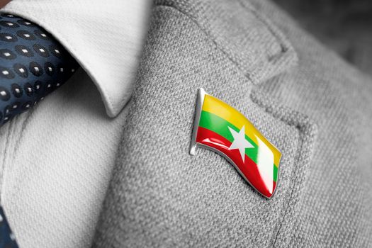 Metal badge with the flag of Myanmar on a suit lapel.