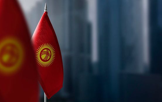 Small flags of Kirghizia on a blurry background of the city.