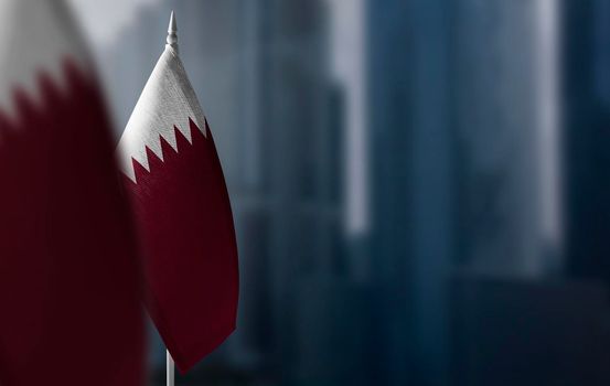 Small flags of Qatar on a blurry background of the city.