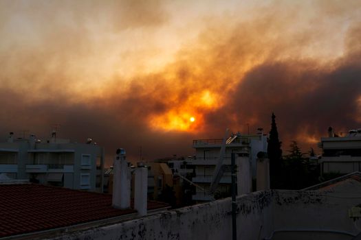 Smoke from the fire in Varibobi at Athens as seen from a house roof. Athens, Greece.