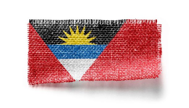 Antigua and Barbuda flag on a piece of cloth on a white background.