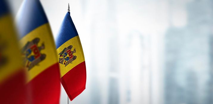 Small flags of Moldavia on a blurry background of the city.