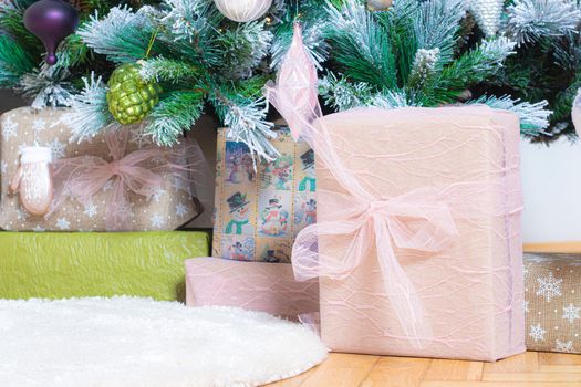 A New Year's gift on the background of a Christmas tree . New Year and Christmas. Gifts for the holiday. Festive mood. A Christmas tree. Bokeh. Copy Space