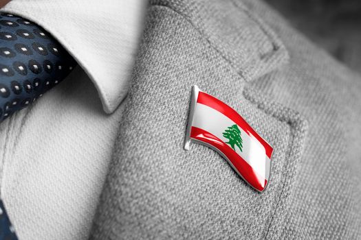 Metal badge with the flag of Lebanon on a suit lapel.