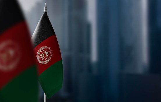 Small flags of Afghanistan on a blurry background of the city.