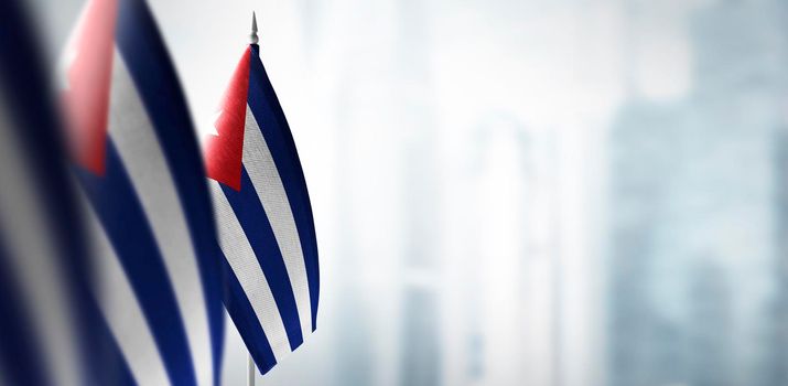 Small flags of Cuba on a blurry background of the city.