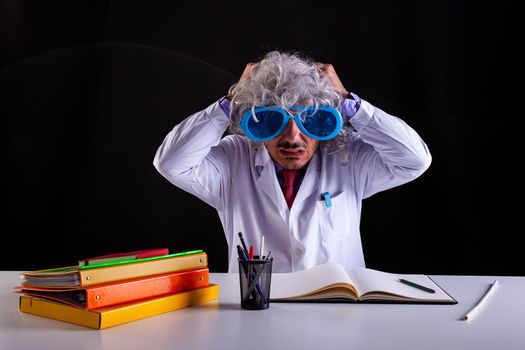 Science teacher in white coat desperate in white coat puts his hands to his hair