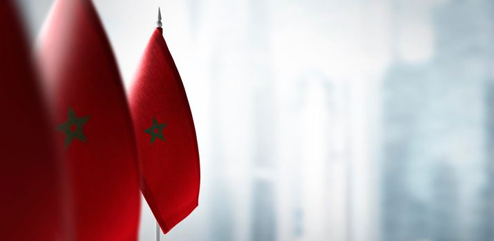 Small flags of Morocco on a blurry background of the city.