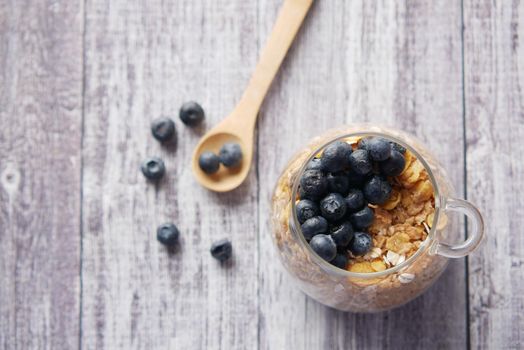 cereal breakfast and blue berry in bowl on table .