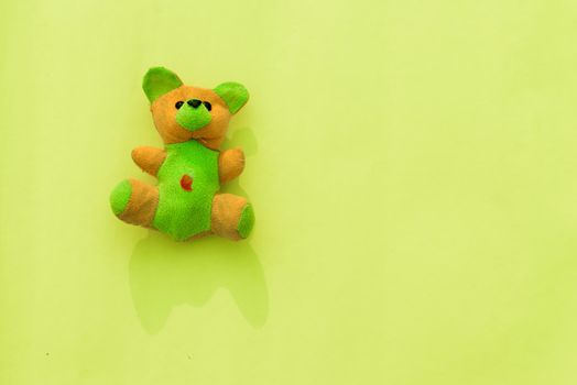 Rabbit teddy bear on yellow color background. Table top view. Flat lay. Copy space for text.