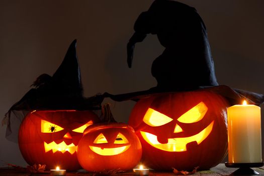 Still life of Halloween pumpkin lanterns pumpkins and hats decoration in candle light