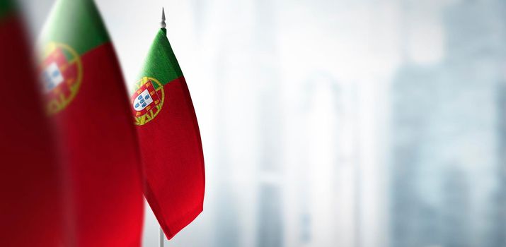 Small flags of Portugal on a blurry background of the city.