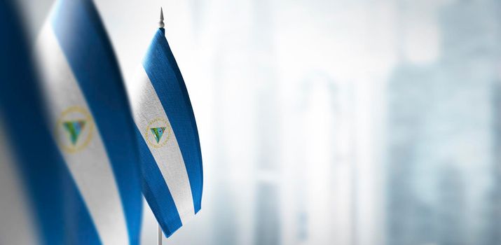 Small flags of Nicaragua on a blurry background of the city.