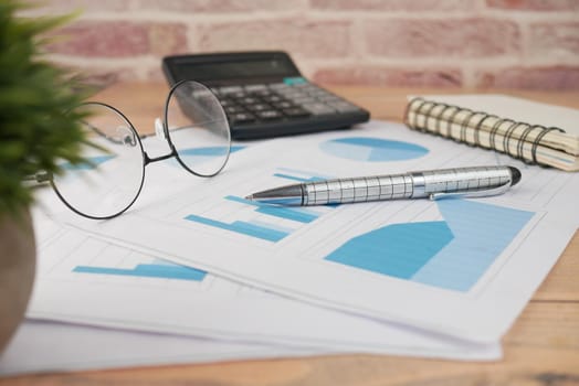 financial graph, calculator and notepad on table.