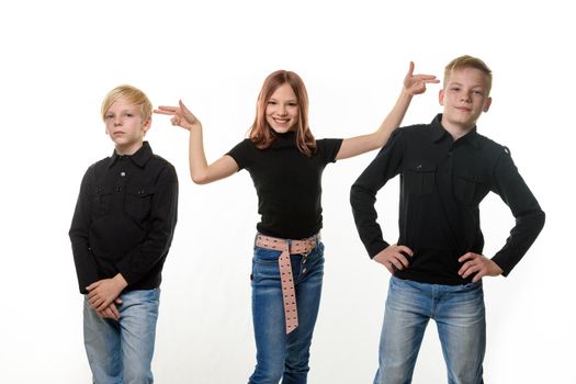 Happy children on a white background, a girl put impromptu pistols to the heads of brothers