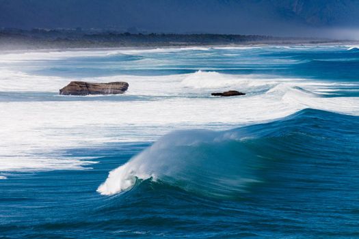 Turbulent water of breaking ocean waves and spray on incoming ocean surf on West Coast of New Zealand South Island