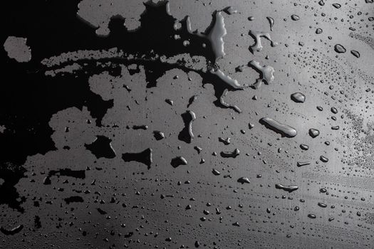 abstract background of wet black hydrophobic surface - close-up with selective focus and skewed perspective