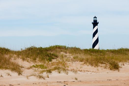 Cape Hatteras Lighthouse towers over beach dunes of Outer Banks island near Buxton, North Carolina, US