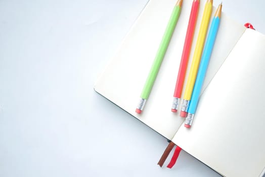 Close up of colorful pencils on notepad .