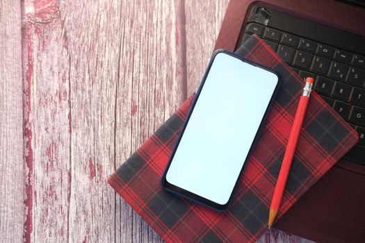 top view of smart phone and notepad on table .