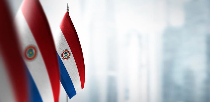 Small flags of Paraguay on a blurry background of the city.