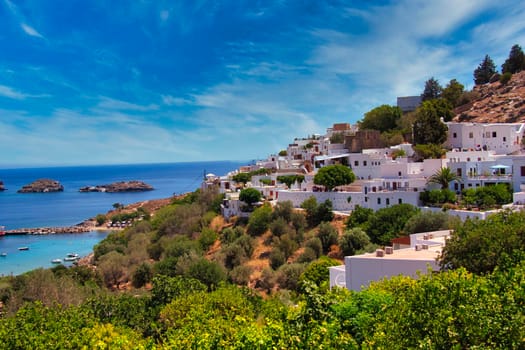 Lindos city with blue sky and some clouds over the sea. High quality photo. Lpvely Skyline of an old city