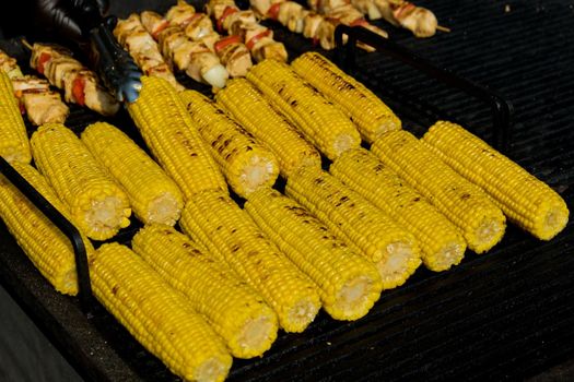Grilling corn cob. Street food festival. Selective focus.