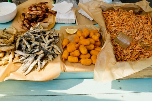 Various fried seafood on the counter ready to eat. Street food festival. Selective focus.