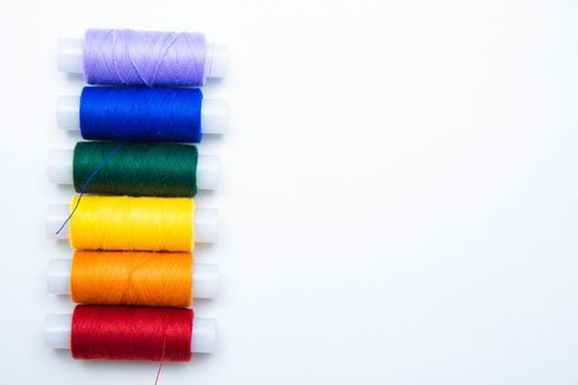 Skeins with threads are lined up in a row according to the color of the rainbow. top view, flat lay, copy space, isolate High quality photo
