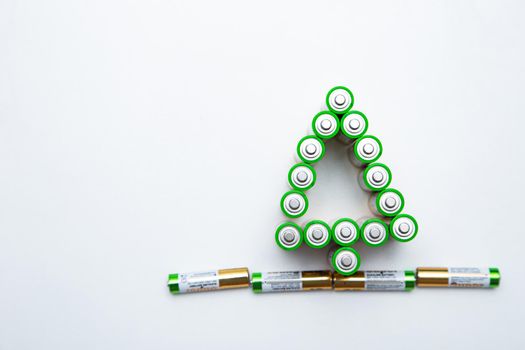 The batteries are in the shape of a Christmas tree on a white background. top view, flat lay, copy space, isolate. High quality photo