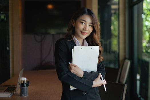 Image of beautiful business woman holds data document at work place.