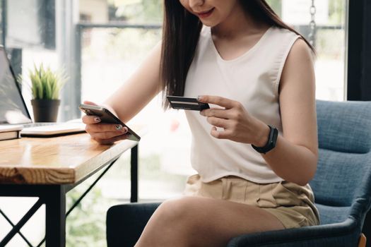 Woman enjoy with online shopping application and typing credit card for fill number to payment