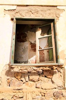 Broken and damaged window in an old house in Spain