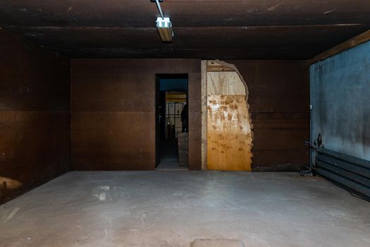 Interior of small room with broken doors and steel brown walls